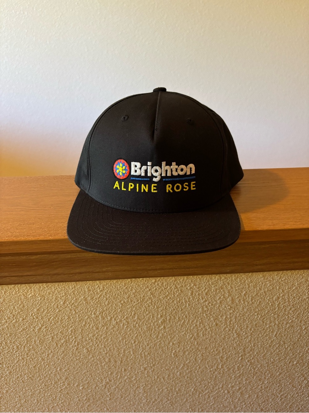 Brighton Black Cap with Multicolor Logo and Yellow Alpine Rose Text